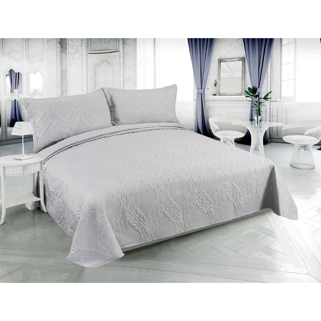 Silver solid embossed pinsonic coverlet and pillow shams set displayed on a modern bed in an elegant, light-filled bedroom.