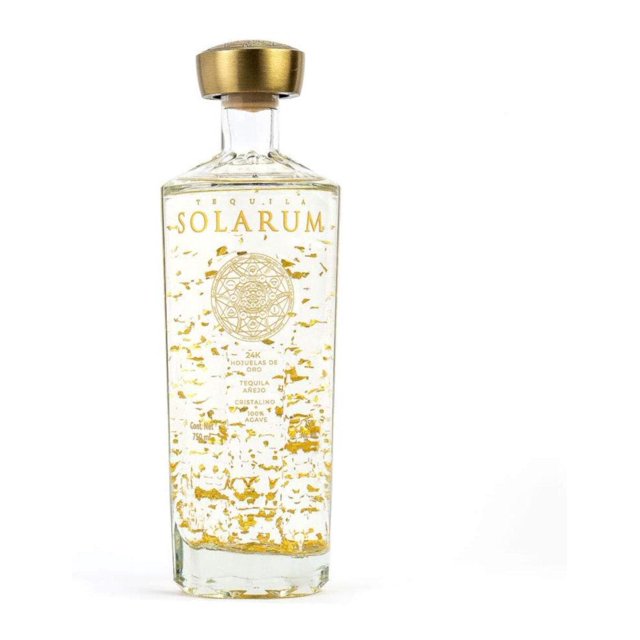 pack de 6 tequila solarum añejo cristalino 750 ml seis botellas, cada botella alta y hexagonal de vidrio transparente con copos dorados en suspensión, etiqueta frontal dorada con logo Solarum y tapa metálica dorada sobre fondo blanco; apto para coctelería o como regalo para mayores de edad.