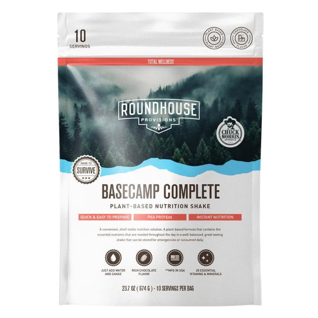 by chuck norris roundhouse provisions basecamp complete nutrition shake: disaster prepper plant based formula with 18g protein and 28 essential vitamins and minerals — front-facing 674 g resealable pouch (10 servings) with forest graphic and brand logos, 'plant-based nutrition shake' label, chocolate flavor and 'just add water' prep note; also suitable for travel or emergency kits.