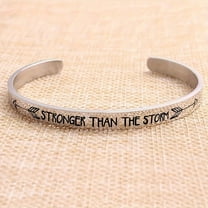 A Personalized Stainless Steel Inspirational Bracelet With An Open Design, Engraved With 'stronger Than The Storm' And Double Arrows On The Outer Side, In The Shape Of A C, Perfect For Christmas