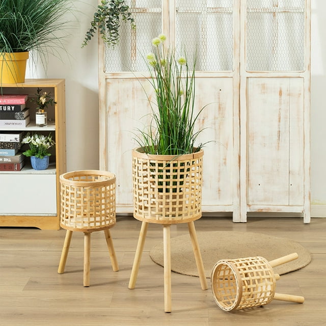 Woven Flower Pot Faux Rattan Planter with wooden legs, available in three sizes, crafted from eco-friendly light brown bamboo weaving. These floor-standing planters feature a rustic, open lattice design, ideal for holding indoor plants, succulents, or faux flowers. Displayed in a cozy indoor setting with plants and decor, showcasing their use as stylish and sustainable bamboo plant stands.