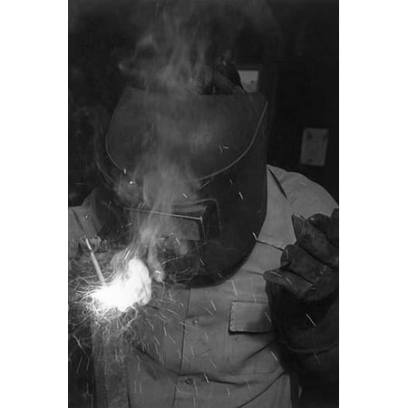 Welder in machine shop half-length portrait standing facing front welding wearing protective gear  Ansel Easton Adams was an American photographer best known for his black-and-white photographs of