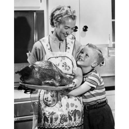 Mid adult woman holding a roast turkey with her son hugging her Canvas Art -  (24 x 36)