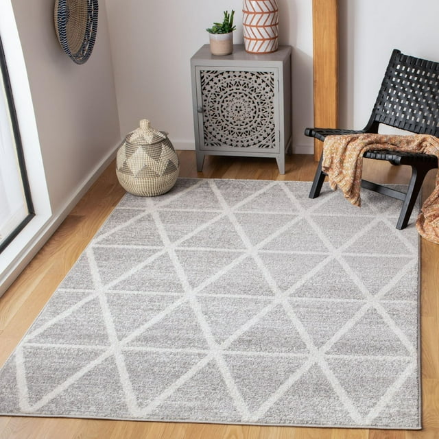 SAFAVIEH Adirondack Darien gray area rug featuring a white geometric triangle pattern on hardwood floor with decorative basket, cabinet, and black woven chair.