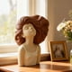 thumbnail image 1 of Escultura de busto de niña, figura de resina – Expresión realista con ojos cerrados y cabello rizado suelto, acabado mate. Decoración para el hogar, ideal para sala de estar, dormitorio, oficina, e, 1 of 6