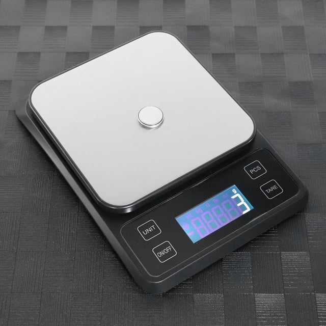 báscula de cocina báscula electrónica de alta precisión acero inoxidable anggrek 3/4 frontal con plataforma cuadrada de acero inoxidable sobre base negra, pantalla LCD azul y botones UNIT/ON·OFF/PCS/TARE; capacidad 5kg/1g, funciona con 3 pilas AAA (no incluidas), almohadillas antideslizantes en la base; también suele usarse para pesar ingredientes y porciones pequeñas en repostería.