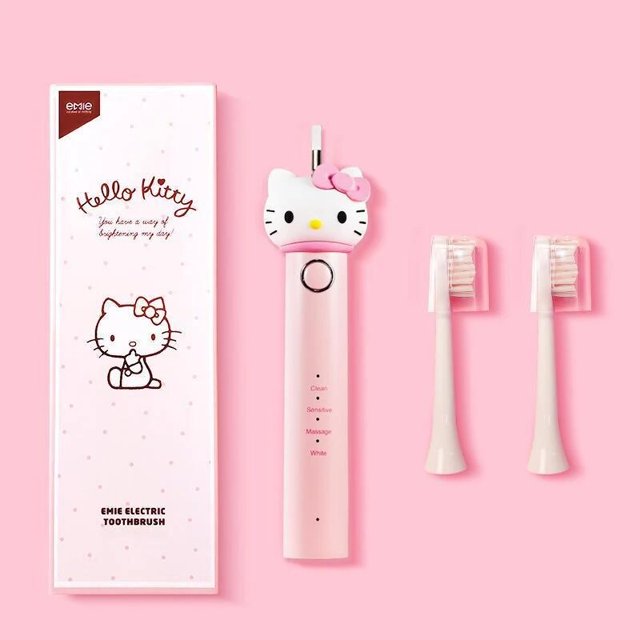 cepillo de dientes eléctrico kawaii sanrio hello kitty kuromi para niños, carga usb, dibujos animados, automático, pelo suave, regalo — Vista frontal centrada de un cepillo eléctrico rosa con cabeza decorativa Hello Kitty, mango cilíndrico con botón y modos marcados (Clean, Sensitive, Massage, White), dos cabezales de recambio de cerdas suaves alineados a la derecha y caja de empaque rosa con ilustración Hello Kitty; especificado para carga USB.