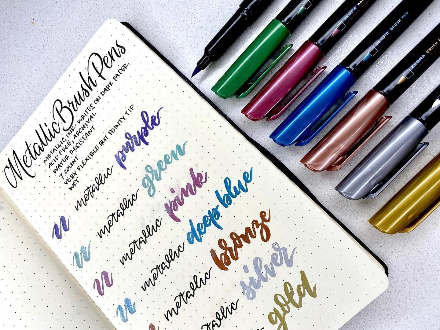 JJEAN-, Metallic Brush Pens, Assorted Metallic Ink Colors, Medium Brush Tip Mimics Artist‘s Paint Brush for Calligraphy, Acid-Free Ink for Light and Dark Paper, 7-Pack (01607)