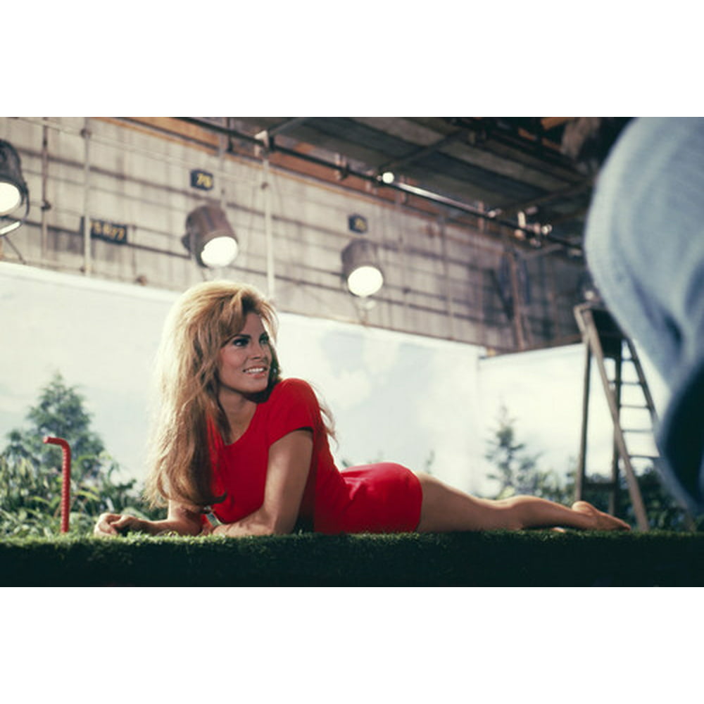 Raquel Welch in Fathom in short red dress lying on fake grass for shoot ...