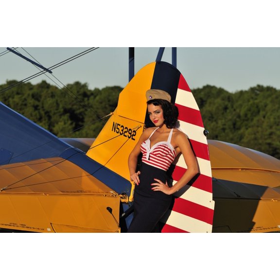 1940s style pin-up girl leaning on the tail fin of a Stearman biplane Canvas Art - Christian KiefferStocktrek Images (18 x 12)