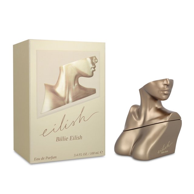 eilish 100ml edp spray Nuevo — frasco dorado con forma abstracta de torso y cuello femenino junto a caja color crema con relieve del mismo torso; fragancia Billie Eilish 100 ml, familia olfativa ámbar vainilla para dama, notas de salida: azúcar, bayas rojas, mandarina; corazón: vainilla, cacao, notas especiadas, rosa; fondo: haba tonka, ámbar, almizcle y notas amaderadas.