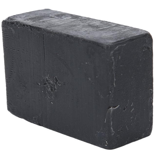 jabón negro, eficaz jabón negro hidratante especial calmante y beneficioso con aceite de aviocado y aceite de argán para una hidratación natural Barra rectangular sólida negra de 120 g con superficie mate y pequeñas marcas, vista 3/4 frontal que muestra bordes ligeramente redondeados; incluye una red de espuma y se suele usar para limpiar e hidratar rostro y cuerpo.