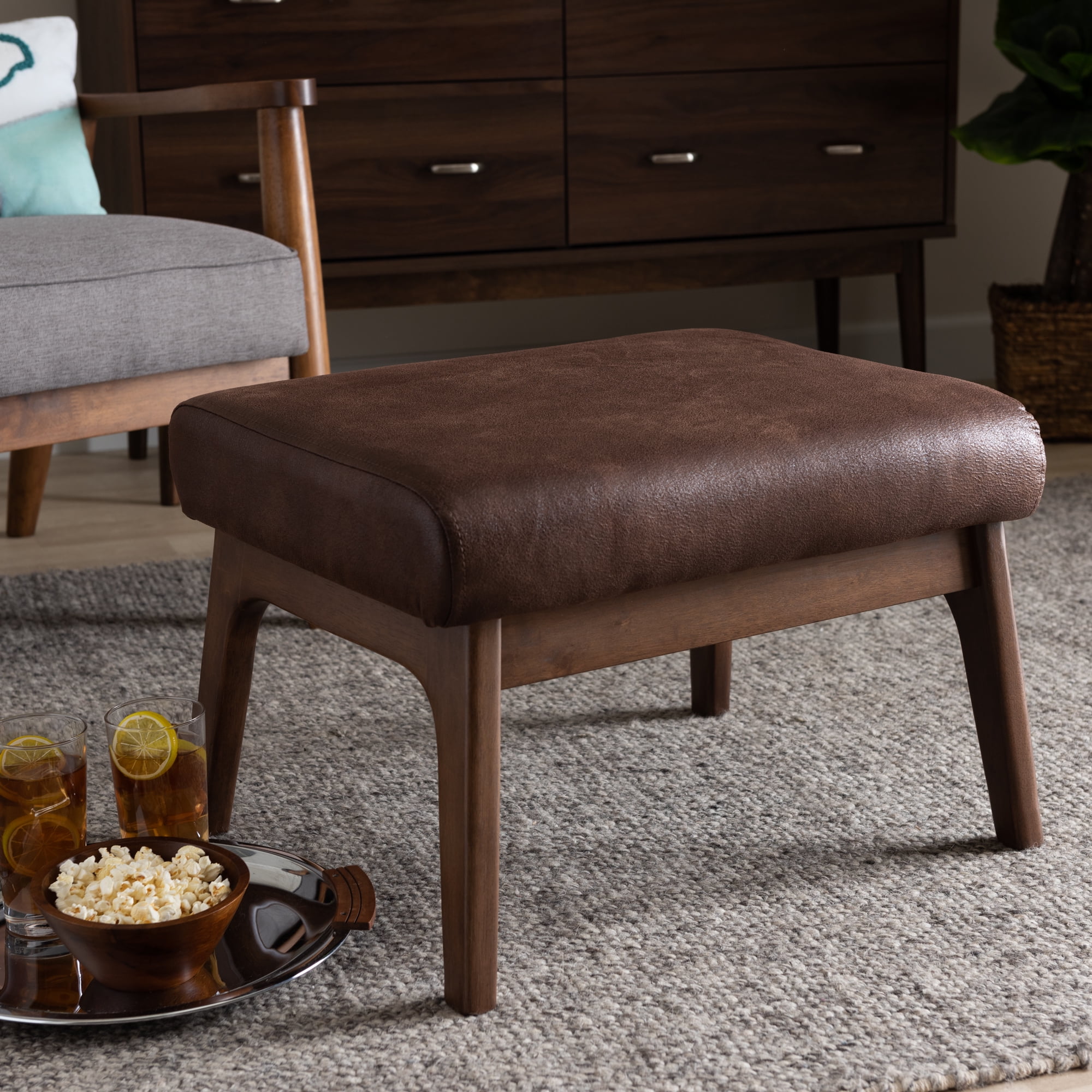 Bakari Mid-Century Modern Walnut Wood Dark Brown Distressed Faux Leather Ottoman by Bellamy Studios