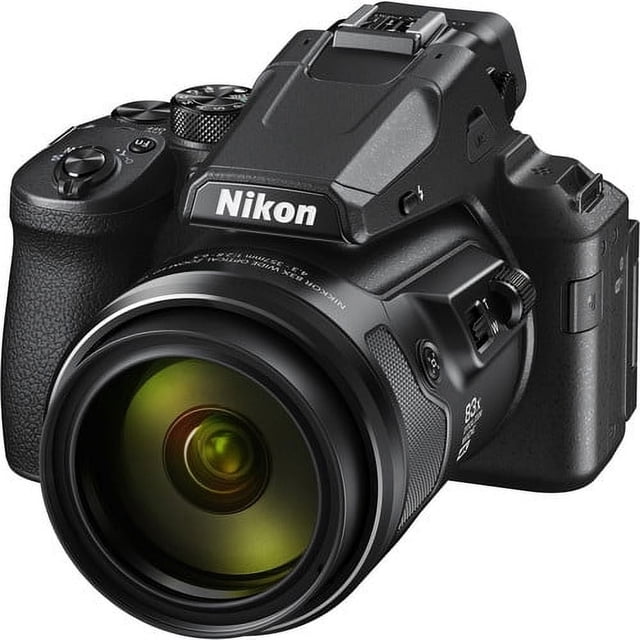 nikon cámara digital coolpix p950 cámara compacta negra en vista 3/4 frontal con gran lente NIKKOR y empuñadura texturizada; zoom óptico 83x visible en el barril (24–2000 mm equivalente), visor electrónico elevado y pantalla LCD abatible; preparada para foto y video UHD 4K con modos Bird y Moon y conectividad Wi‑Fi/Bluetooth; frecuentemente usada para fotografía de viaje y sujetos distantes.