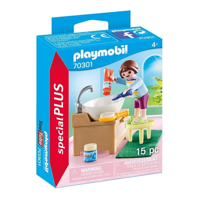 niña con lavabo playmobil special plus 15 piezas Figura de niña Playmobil junto a lavabo blanco sobre mueble beige con grifo plateado; incluye taburete verde, cepillo, pasta dental y frasco pequeño como accesorios, empaque Special Plus visible.
