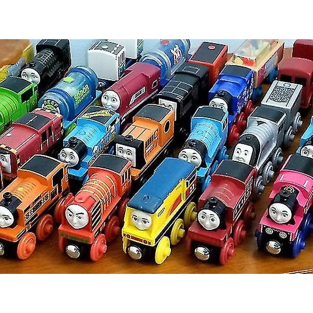 thomas y sus amigos tren tanque motor ferrocarril de madera imán recoger juguetes de regalo Vista cenital de varias locomotoras de madera estilo Thomas y sus amigos colocadas en filas; pinturas en colores variados, ruedas de madera y ejes visibles, caras impresas en la proa, tamaño marcado aprox. 7–11 cm, marca DM Imports, venta a granel con posibles pequeñas imperfecciones. Ideal para colecciones de trenes en miniatura.