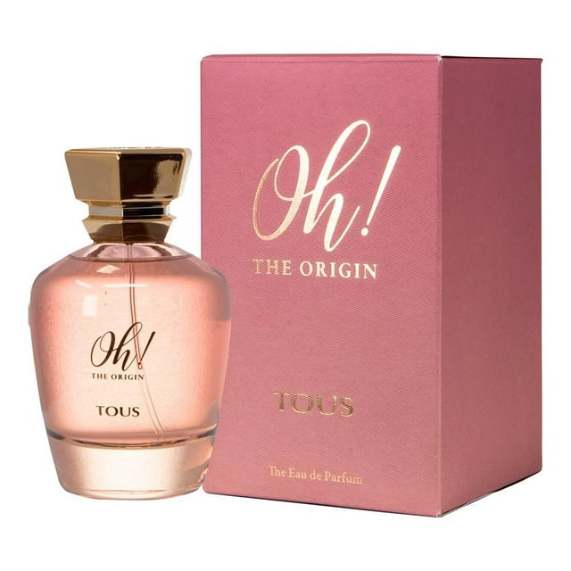 Perfume Tous Oh! The Origin EDT 100 ml shows a rounded glass bottle with transparent pink liquid and a gold hexagonal cap, next to its pink box with gold embossed lettering. This floral fruity fragrance is ideal for feminine elegance and style.