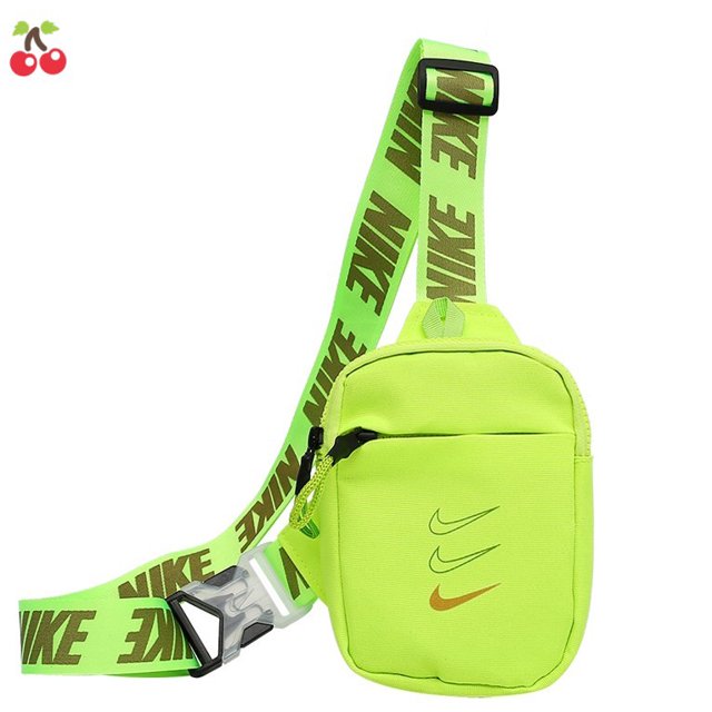 bolso bandolera nike sport cintura pecho pareja hombro 18 * 15 * 5cm verde, vista frontal centrada de bolsa pequeña de lienzo con cremallera, correa ancha ajustable con texto NIKE en verde oscuro, tres swoosh en el frente y hebilla plástica lateral; compacto para uso en pecho o cintura, a menudo usado para llevar llaves y pequeños accesorios.