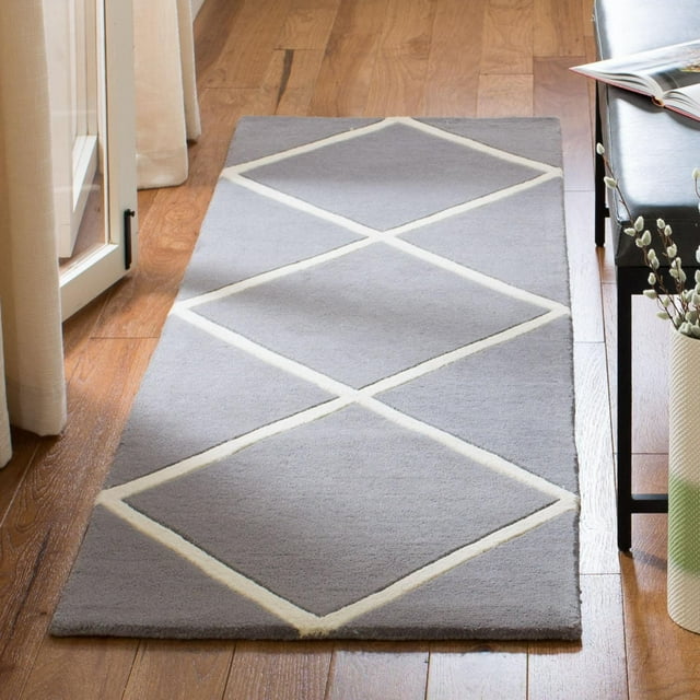 Safavieh Chatham Isaac gray area rug featuring a white geometric diamond design placed on hardwood flooring next to furniture.