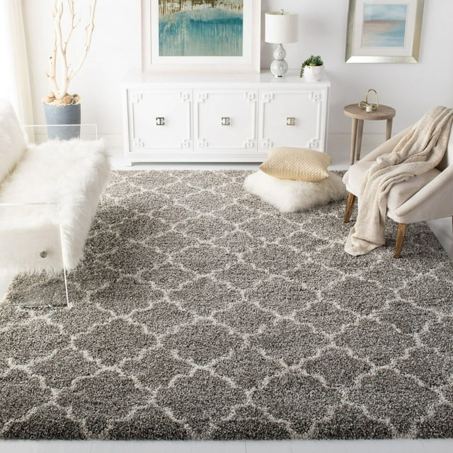 Safavieh Hudson Jaye gray and white geometric shag area rug displayed in a bright, modern living room with minimalist furniture.