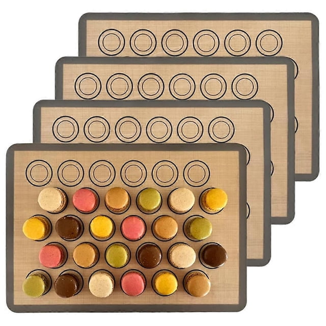 macaron baking mats 4 pack for perfect macarons & cook - silicone macaron baking sheets with size guiding circles Juego de cuatro alfombrillas de silicón para macarons 420x295mm, color beige con borde café oscuro y círculos guía impresos para pipear macarons de tamaño uniforme; mostradas apiladas con la primera alfombrilla con macarons surtidos colocados, también aptas como forro de horno o tapete para amasar.