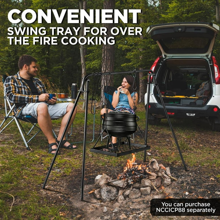 Metal tea kettle heating up over a campfire stock photo - OFFSET