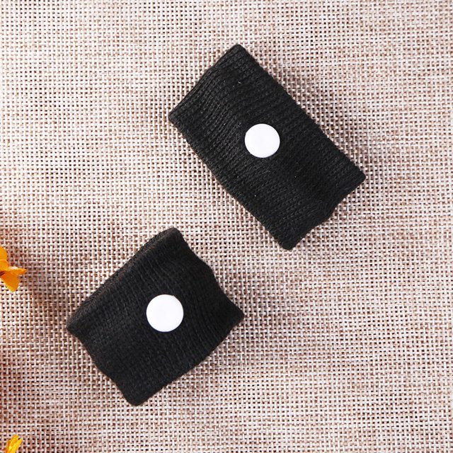 náuseas muñequera pulsera prácticas bandas enfermedades acupressura aliveración mubliblas problante nausea frabajas Pulsera anti mareo negra, vista cenital de dos bandas elásticas de poliéster con botón blanco circular sobre fondo de tela; 55 mm × 25 mm × 10 mm, 19 g, diseñada para viajes y uso diario.