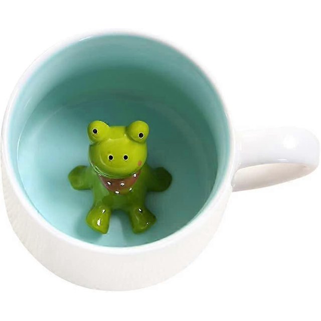 cute frog coffee mug, ceramic mug with 3d animal taza de cerámica blanca con interior azul claro y rana 3D verde en el fondo; medidas 116 x 87 x 65 mm, sin cuchara ni platillo, apta para microondas y lavavajillas; por ser hecha a mano puede presentar pequeñas variaciones.