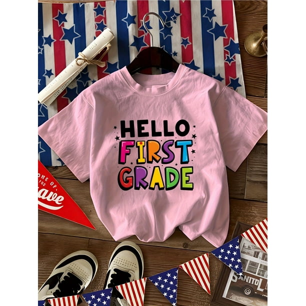 Camiseta de algodón para niña. Camiseta de algodón para niña con estampado de letras "Hola, primer grado" y estampado de estrellas. Cómoda e informal, cuello redondo y manga corta.