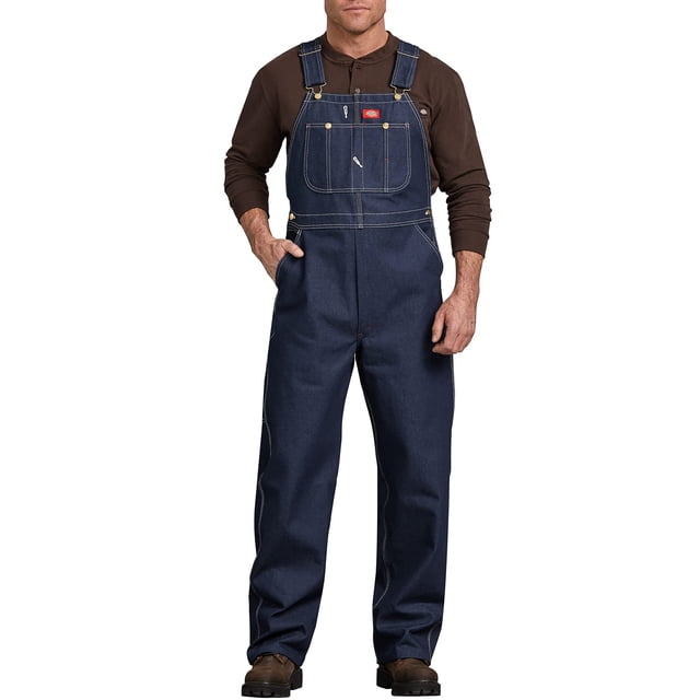 dickies - monos y overoles con pechera para hombre, ropa de trabajo indigo rigid 44w x 32l us overol frontal; mezclilla índigo rígido con pechera con bolsillo grande dividido para lápices, bolsillo doble para teléfono, costuras triples visibles, tirantes cruzados ajustables con hebillas metálicas, lazo para martillo en la cadera, piernas rectas y espaciosas que cubren botas, modelo de pie sobre fondo blanco; a menudo usado también como prenda resistente para tareas de taller y para guardar herramientas pequeñas.
