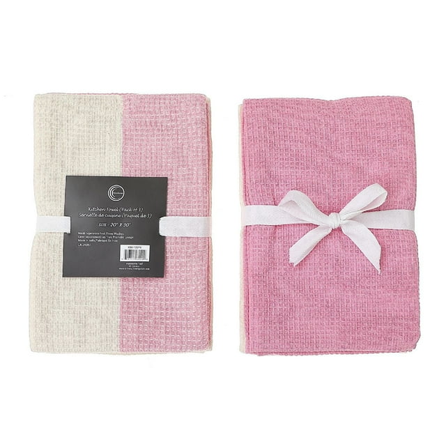 Set of three dual waffle weave kitchen towels in blush pink and cream colors, neatly folded and secured with white ribbons.