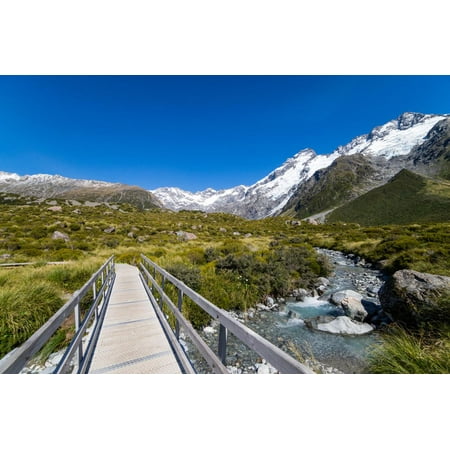 A hiking trail crosses wooden bridge over a creak high up in the mountains, New Zealand Print Wall Art By Logan
