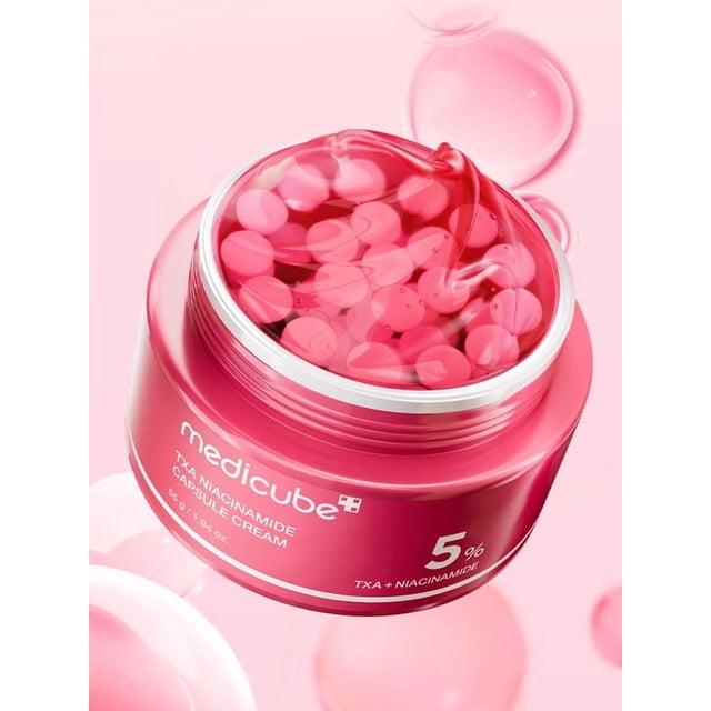 Medicube TXA Niacinamide Capsule Cream 55g, a face moisturizer in a pink jar with visible capsules. Formulated with 99% pure tranexamic acid, 5% niacinamide, alpha-arbutin, and glutathione, it helps refine skin tone, hydrate, and promote a radiant appearance. The customizable capsule-gel system allows for tailored application, offering lightweight or richer textures for day or night use. Enriched with hyaluronic acid, ceramides, and vitamin C, it supports balanced moisture and skin barrier health.
