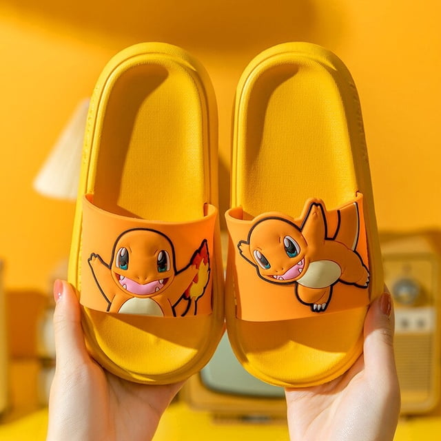 zapatillas de pikachu de pokemon para niños y niñas, chanclas de interior unisex, zapatos planos antideslizantes de baño, sandalias de playa, regalo para niños — Vista frontal centrada de sandalias amarillas talla única en PVC con correa ancha decorada con un personaje Pokémon estilo Pikachu; suela plana antideslizante y plantilla acolchada visible, sostenidas por manos sobre fondo amarillo; también son adecuadas como calzado cómodo para piscina o playa.