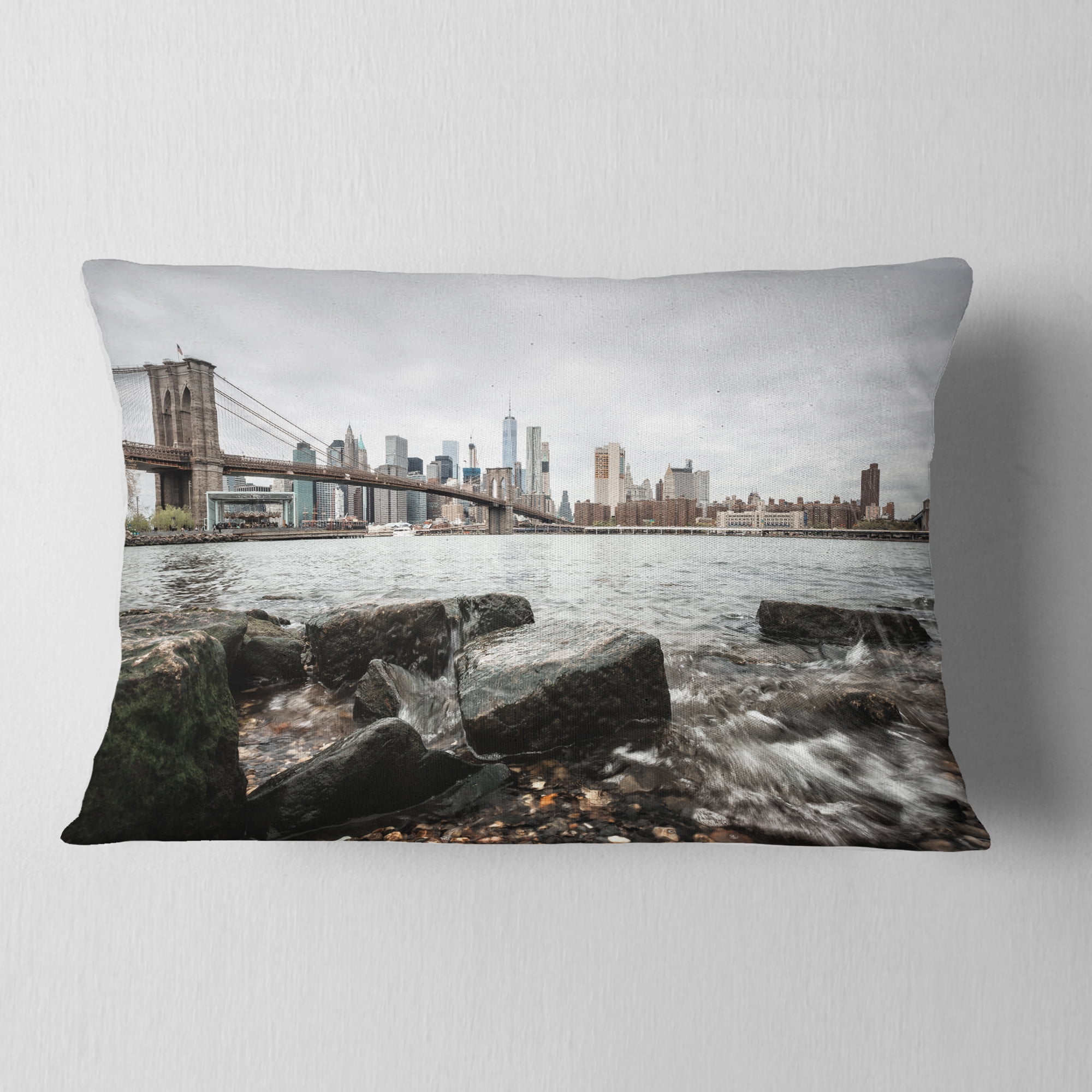 Designart Brooklyn Bridge with Rocks on Shore - Cityscape Throw Pillow - 12x20