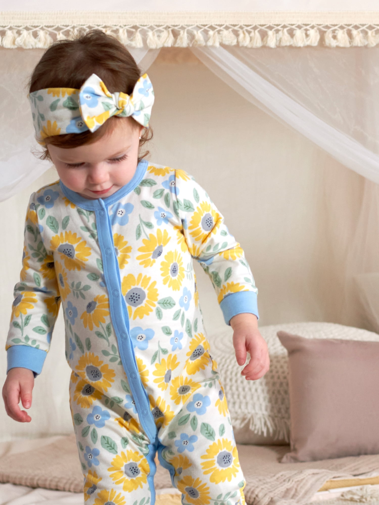 Bright Spring Jumpsuits For Newborns Hang On Hangers In A