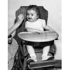 Baby feeding in high chair Poster Print