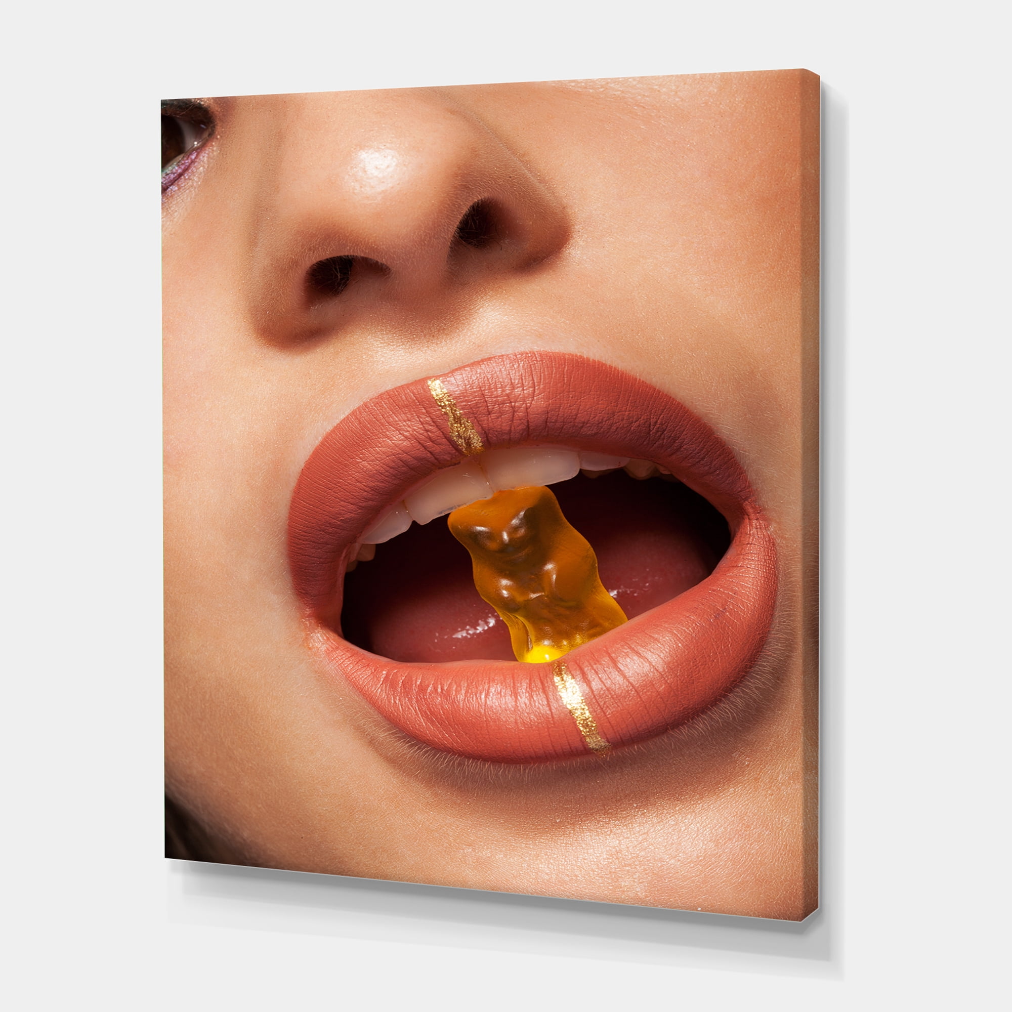 Designart ' Close Up VIew of Female Lips Biting Gummy Bear ' Modern Canvas Wall Art Print