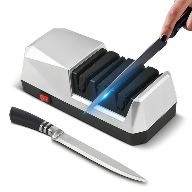 Electric Knife Sharpener Multifunctional 3-Stage Slots Kitchen Knives Sharpening System in a grey and black design. Features three sharpening slots for coarse grinding, fine grinding, and polishing, with a visible on/off switch on the side. A knife is being sharpened in one of the slots, emitting a blue light effect, while another knife rests nearby. Suitable for straight edge knives, serrated knives, ceramic knives, and scissors.