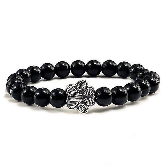 Pulsera con dije de huella de pata de piedra volcánica de lava negra mate natural, ideal como recuerdo para mascotas, amantes de los gatos y los perros.