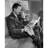 Father reading a book with his son sitting on his lap Poster Print