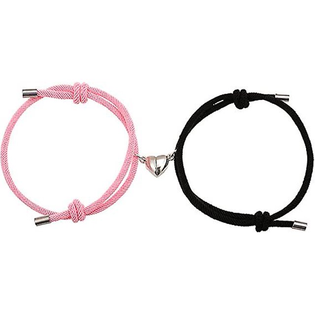 pulsera magnética para parejas (amor en negro y rosa), pulsera de pareja como regalo para un novio o una novia, una mujer y tu amante, 2 Par de pulseras ajustables de cordón de nylon —una rosa y una negra— con nudos corredizos y terminales metálicos; colgante magnético de acero inoxidable en forma de corazón partido que se atrae, vista frontal sobre fondo blanco; también suelen usarse como cierre simbólico para llaveros o accesorios pequeños.