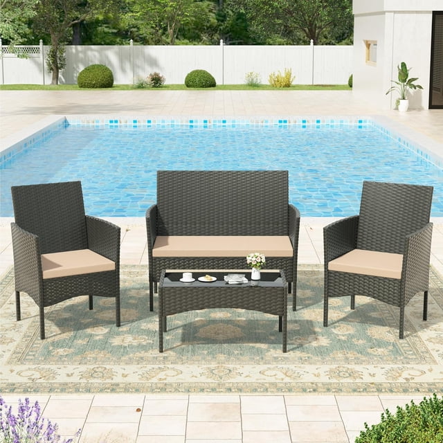 Kullavik 4 Pieces Outdoor Patio Furniture Set featuring two single seat rattan chairs, one double seat rattan sofa, and a tempered glass coffee table. The set includes sand-coloured soft cushions and is designed for outdoor use in areas like lawns, poolsides, or backyards. The furniture is made of durable PE wicker and a stainless steel frame, offering weather resistance and ergonomic comfort. Displayed in a poolside setting with a patterned outdoor rug.