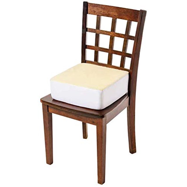Comfort Finds Rise With Ease Seat Cushion in Sherpa Cream, shown placed on a wooden chair. This thick, firm booster cushion measures 14 x 14 x 5 inches and features a dense polyurethane foam core for extra supportive lift. The cushion includes a removable, machine-washable Sherpa cover with breathable cotton knit sides and bottom, designed to provide elevation and support for lower back and spine. Ideal for home, patio, office, or car seats.