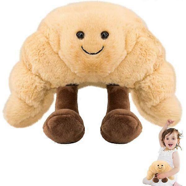 croissant plush, creative soft smiling food plush, soft simulation smiley croissant toy, party decorations bread pillow — peluche croissant beige con cara sonriente bordada y ojos negros, forma curva acolchada de 19x17cm, felpa suave y patas cortas marrón; vista frontal centrada sobre fondo blanco, adecuado como regalo de cumpleaños o Día del Niño y suele usarse también como cojín decorativo en fiestas.