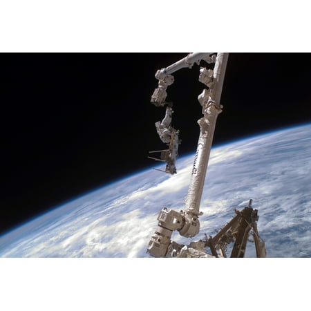 An astronaut anchored to the International Space Stations Canadarm2 foot restraint Stretched Canvas - Stocktrek Images (34 x