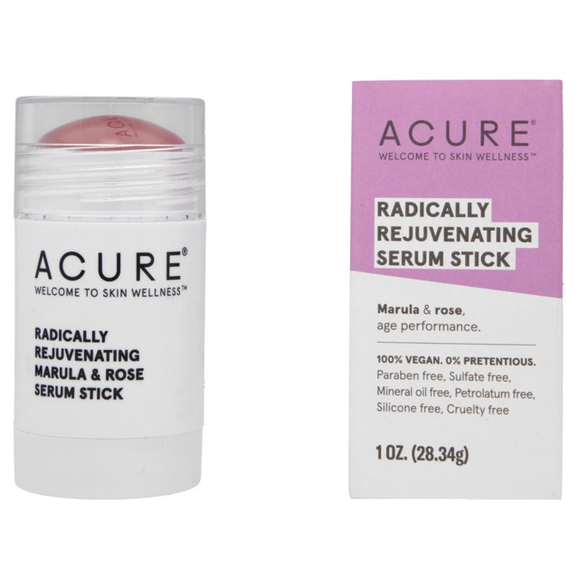 acure. radically rejuvenating serum stick, suero sólido antiedad de fácil aplicación — Envase blanco con tapa transparente y barra crema-rosada en primer plano; caja rosa y blanca a la derecha con texto de marca y peso 1 oz (28.34 g). Suero sólido antienvejecimiento con aceite de marula y aceite de rosa, formulado para combatir la apariencia de piel opaca y apagada; a menudo usado como bálsamo hidratante puntual para zonas secas.