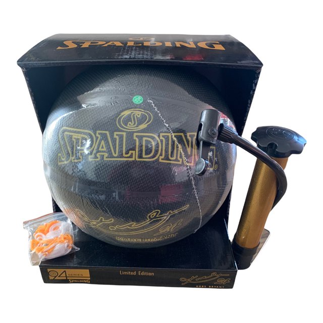 balon basketbol spalding kobe bryant edicion limitada — Balón de baloncesto negro Serie 94 con logo Spalding en dorado, textura que imita piel de serpiente "Black Mamba" y firma impresa en dorado; mostrado en caja con inflador metálico dorado y kit de válvula, también apto para exhibición o uso recreativo.