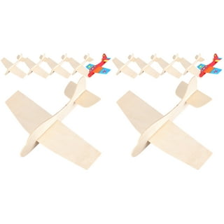 Handcrafting model airplane from wood. Wooden air plane handcrafted with balsa  wood, on work table by the window. Airplane, cutter knife, balsa wood  material and glue on table. Top view. Stock Photo