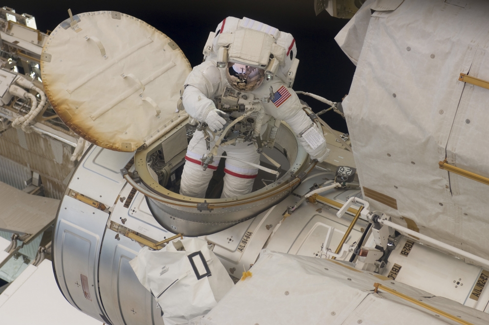 Astronaut ingresses the airlock hatch on the International Space Station Stretched Canvas